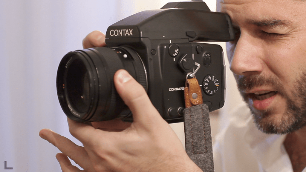 Greg Finck en train de photographier avec son appareil photo argentique Contax 645